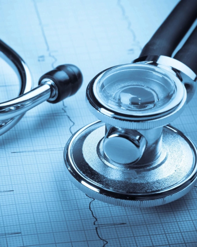 A stethoscope and a medical device on top of a table.